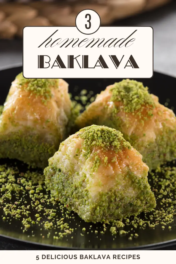 Three pieces of homemade baklava topped with finely ground pistachios on a black plate.