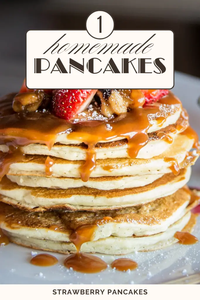 A stack of pancakes topped with strawberries and caramel sauce.