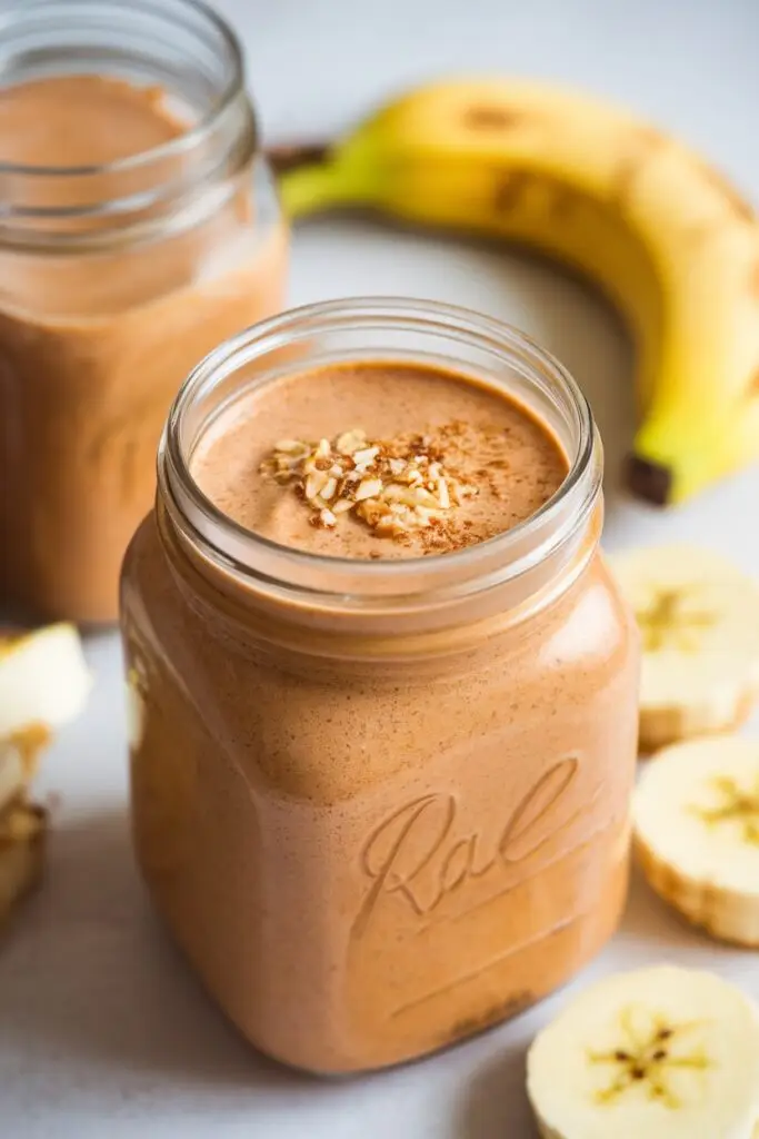 A creamy apple banana almond butter smoothie in a mason jar.