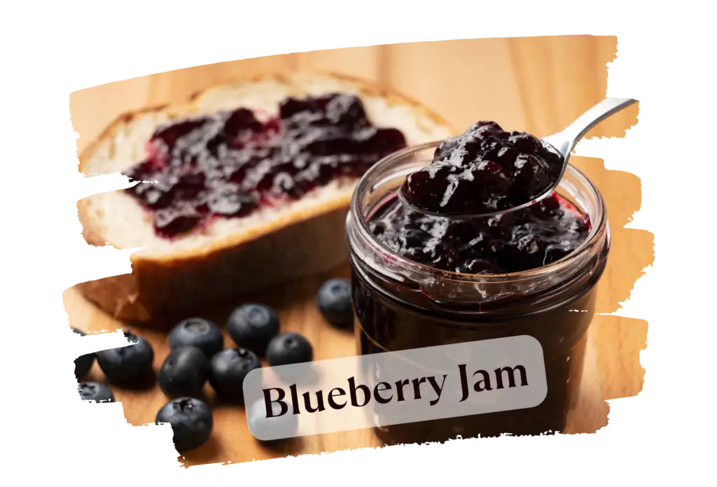 A jar of blueberry jam with a spoon, next to a slice of bread topped with jam and fresh blueberries.