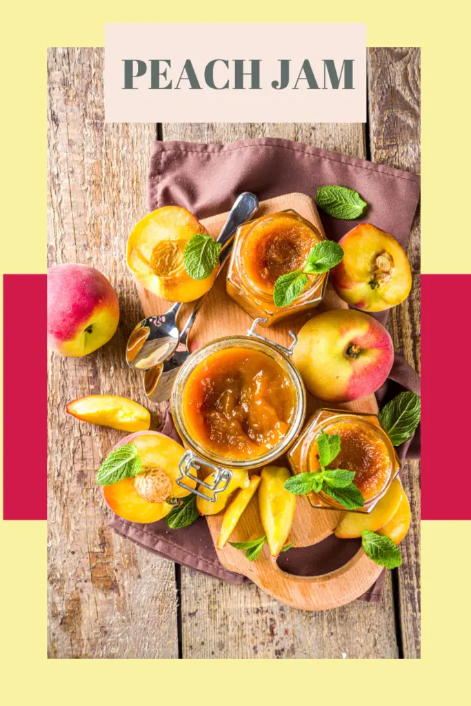 A Mason jar filled with preserved peach slices in syrup, surrounded by fresh whole and halved peaches on a light-colored surface, with a wooden spoon nearby and a warm, softly blurred kitchen background.