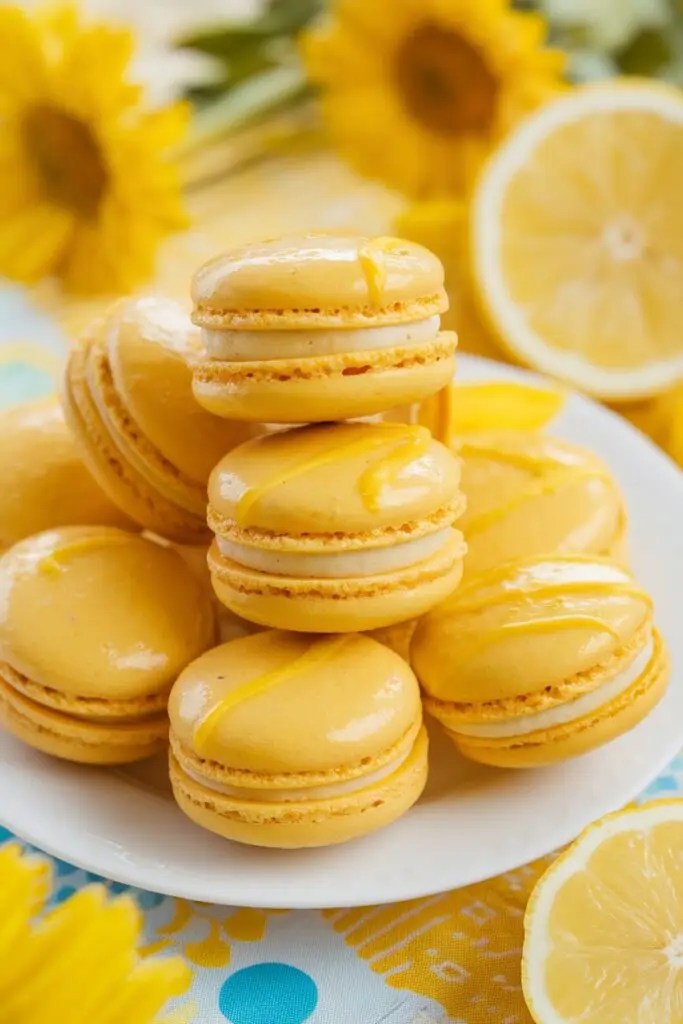 A bright and cheerful stack of yellow macarons with a drizzle of lemon glaze.